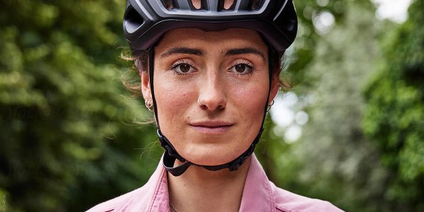 A women is smiling wearing a helmet 